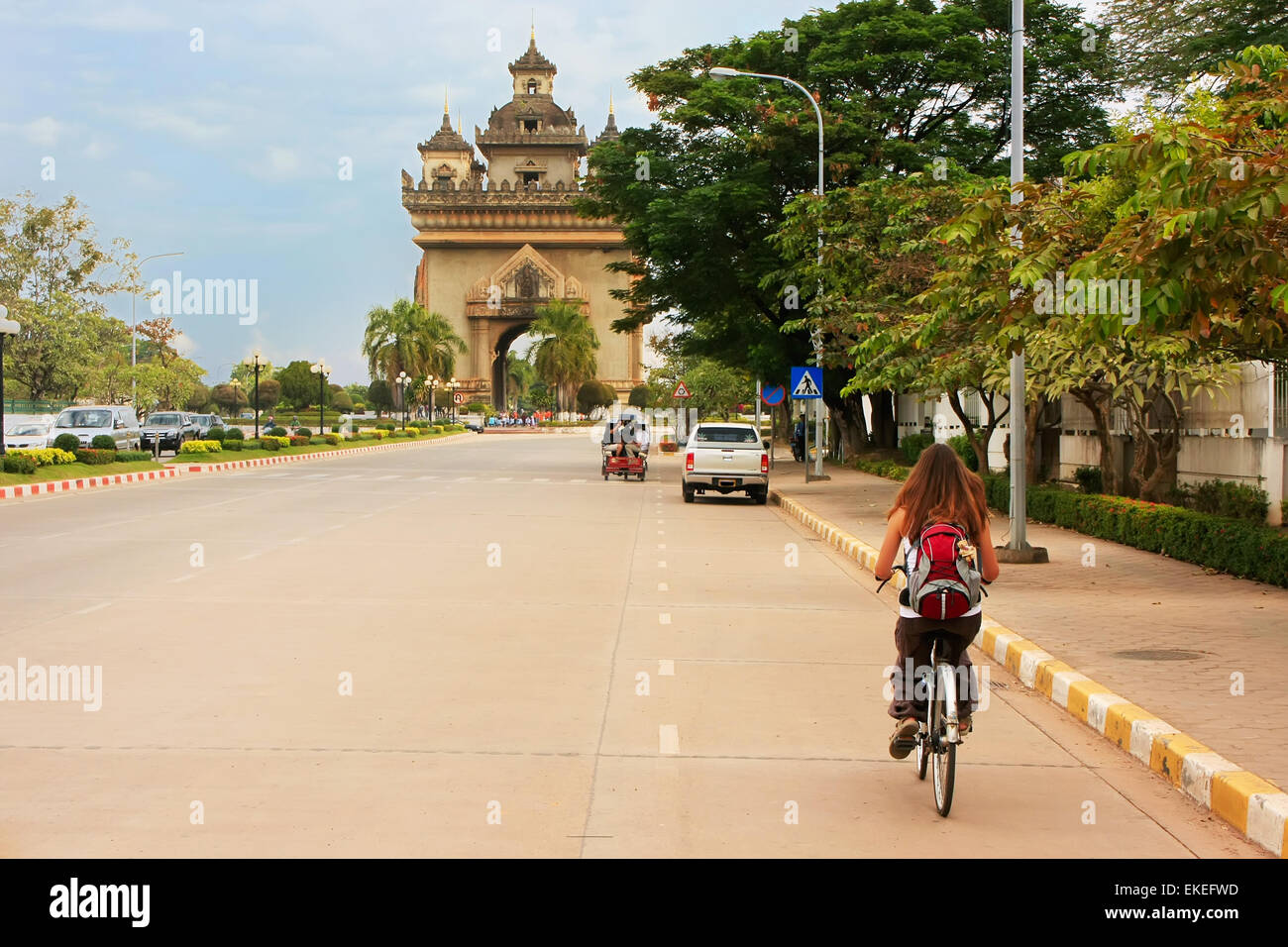 Jeune femme équitation vélo près de la Victoire Patuxai, Vientiane, Laos, Asie du sud-est Banque D'Images