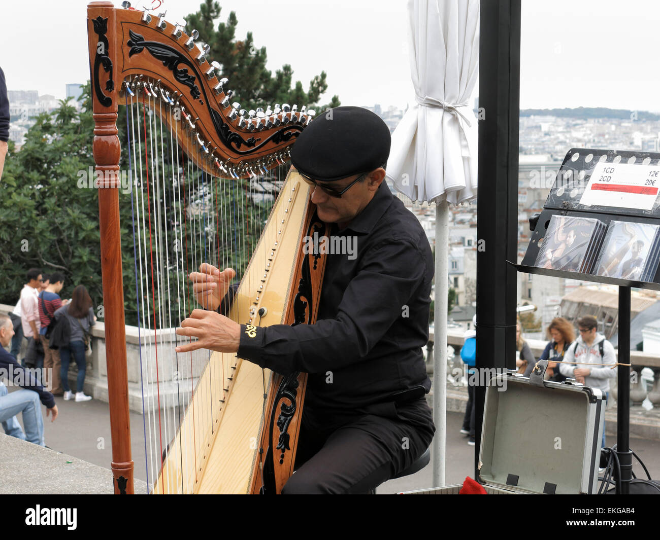 Un musicien de rue jouant de la Harpe sur les marches du Sacré-Cœur à Paris. Banque D'Images