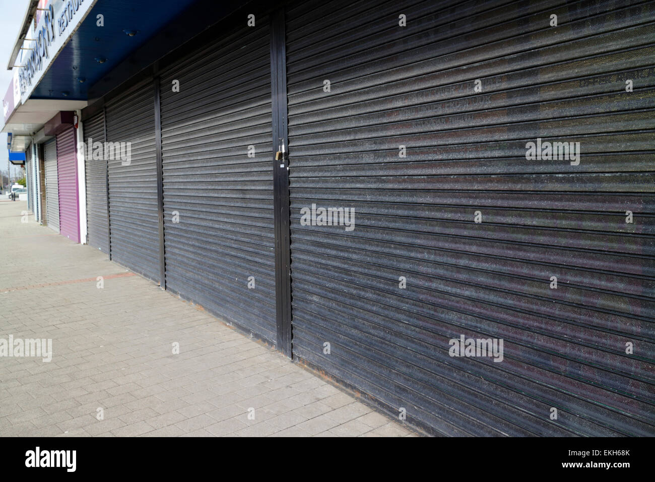 Volets de sécurité métalliques sur des ateliers fermés sur un high street au Royaume-Uni Banque D'Images