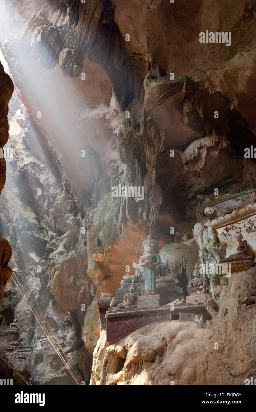 La grotte de Chiang Dao, Chiang Rai, Thaïlande du Nord. Formations calcaires, près de l'entrée avec des statues bouddhistes, sunbeam breaking Banque D'Images