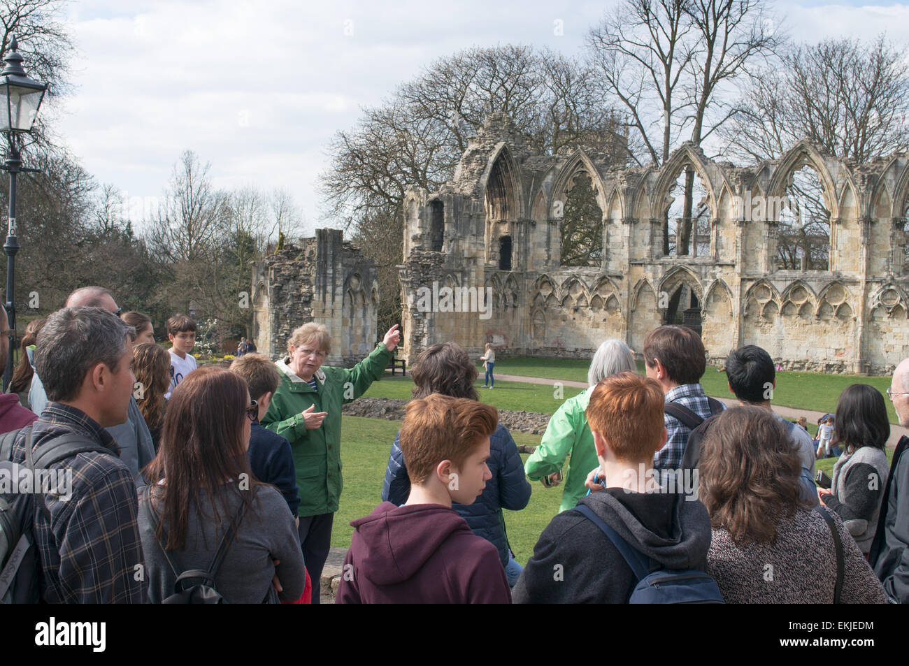 Guide touristique avec un groupe de touristes dans les jardins du musée, de la ville de York, England, UK Banque D'Images