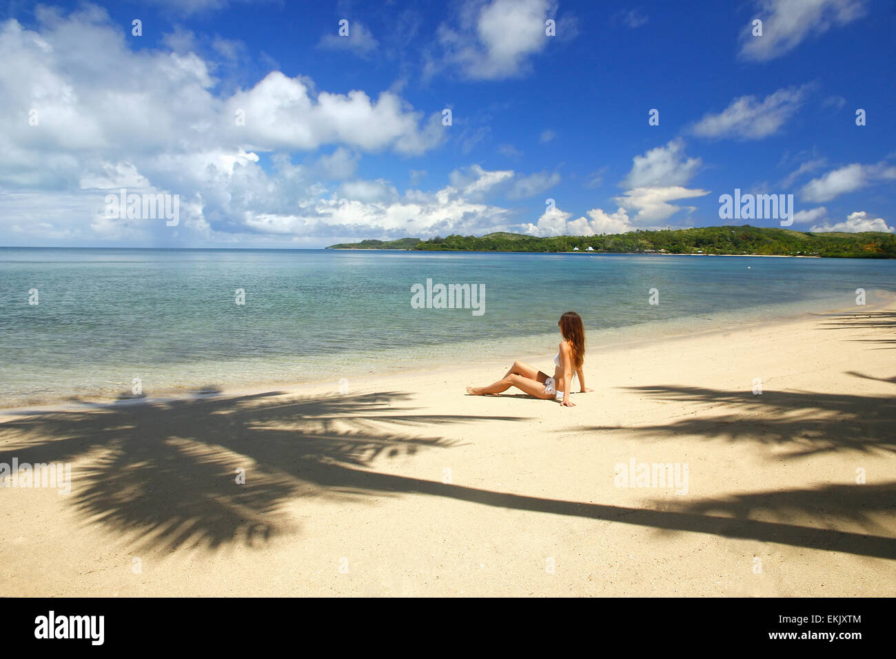 Young woman in bikini assis sur une plage tropicale, Nananu-i-ra island, Fidji, Pacifique Sud Banque D'Images