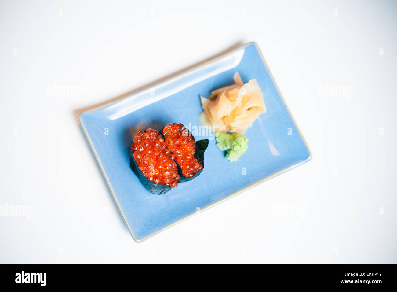 Gunkan sushi, sur plaque bleue au gingembre et wasabi, fond blanc Banque D'Images