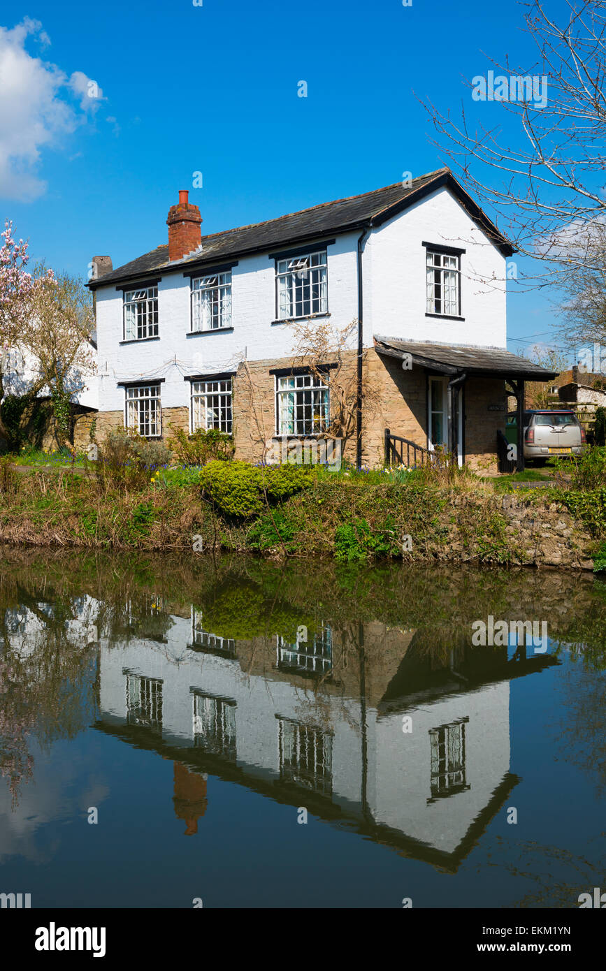 Une maison reflète dans la rivière Flèche à Eardisland, Herefordshire, Angleterre. Banque D'Images