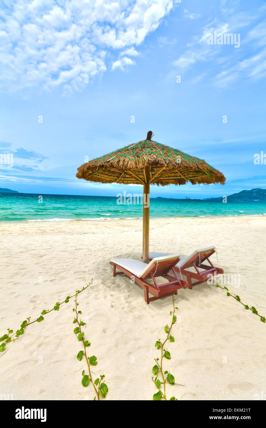 Sandy tropical beach avec chaises longues en journée ensoleillée Banque D'Images