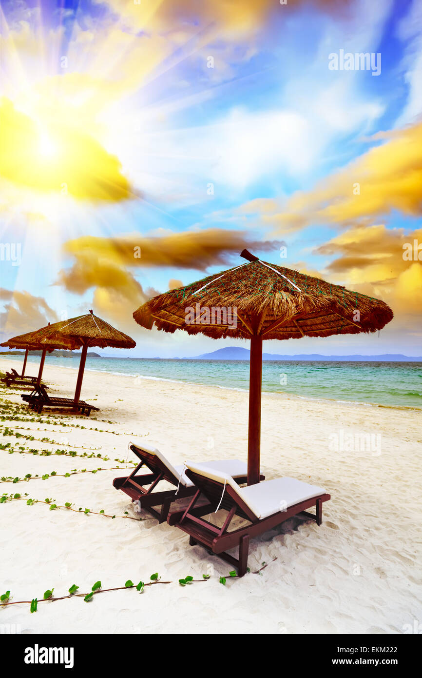 Sandy tropical beach avec chaises longues en journée ensoleillée Banque D'Images