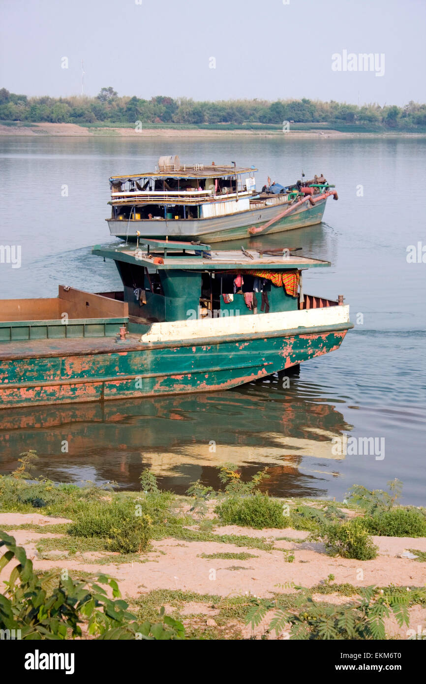 Les bateaux utilisés pour l'industrie lourde sont considérées à partir de la rive du Mékong dans la région de Kampong Cham, au Cambodge. Banque D'Images