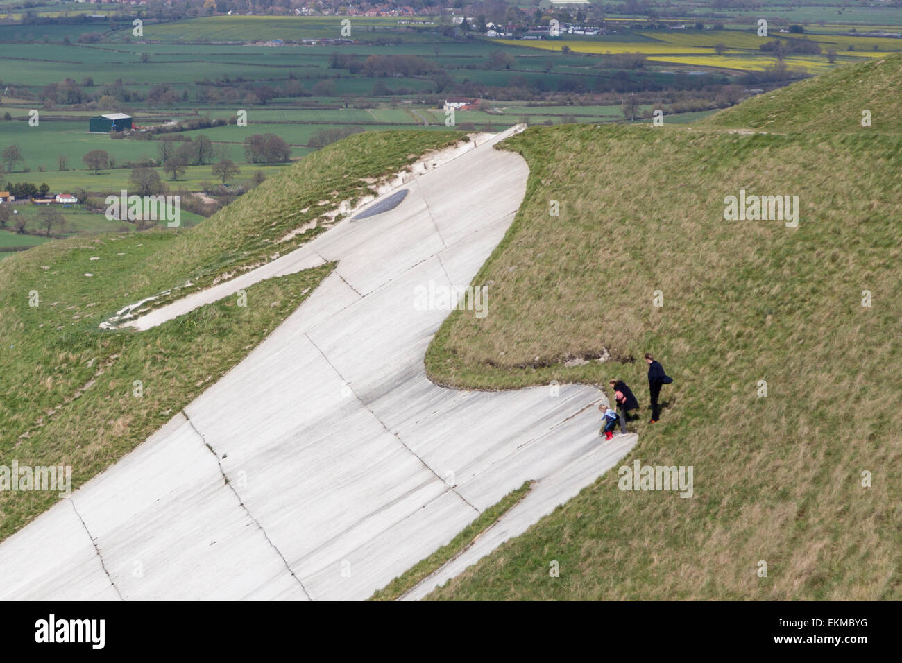 Wiltshire, Royaume-Uni. 12 avril, 2015. Météo France : Forte haut vent soufflant sur le cheval blanc de craie au-dessus de la ville de Westbury. Les vents forts n'a pas arrêté de nombreux membres de la population de visiter et d'utiliser le temps de marche, promenade des chiens, voler des cerfs-volants et profiter de la vue imprenable sur toute la vallée du Wiltshire. Le site est protégé par l'English Heritage qui maintiennent l'ancien âge de fer de la saison de pâturage fort en permettant aux troupeaux de moutons pour maintenir les herbes et broussailles chalk favorable plantes. Credit : Wayne Farrell/Alamy Live News Banque D'Images