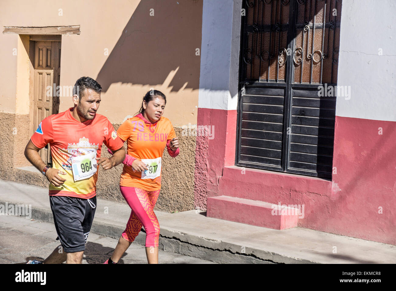 L'homme athlétique avec grande fille courir à San Cristobal de las Casas le demi-marathon d'anciens bâtiments colorés Chiapas Banque D'Images