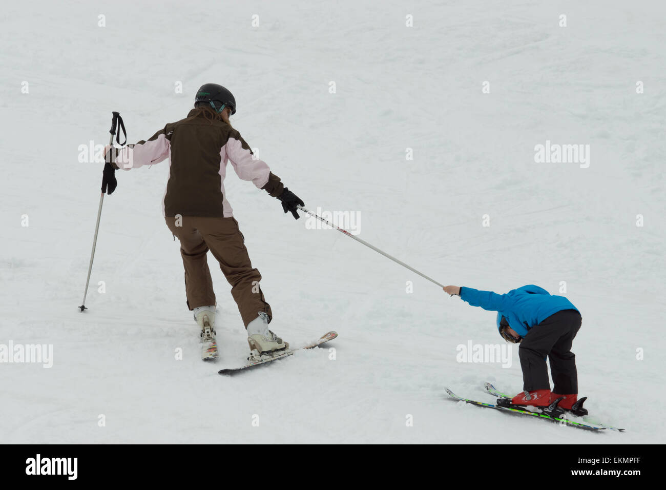 Parenting ski enfant têtu tirant jusqu'à vélo Banque D'Images