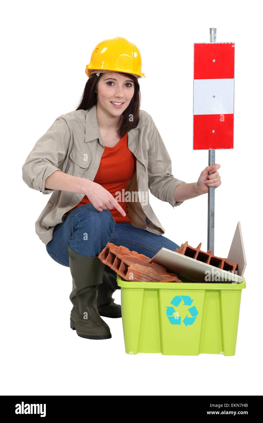 Female construction worker vous avertissant de recycler d'anciens matériels Banque D'Images