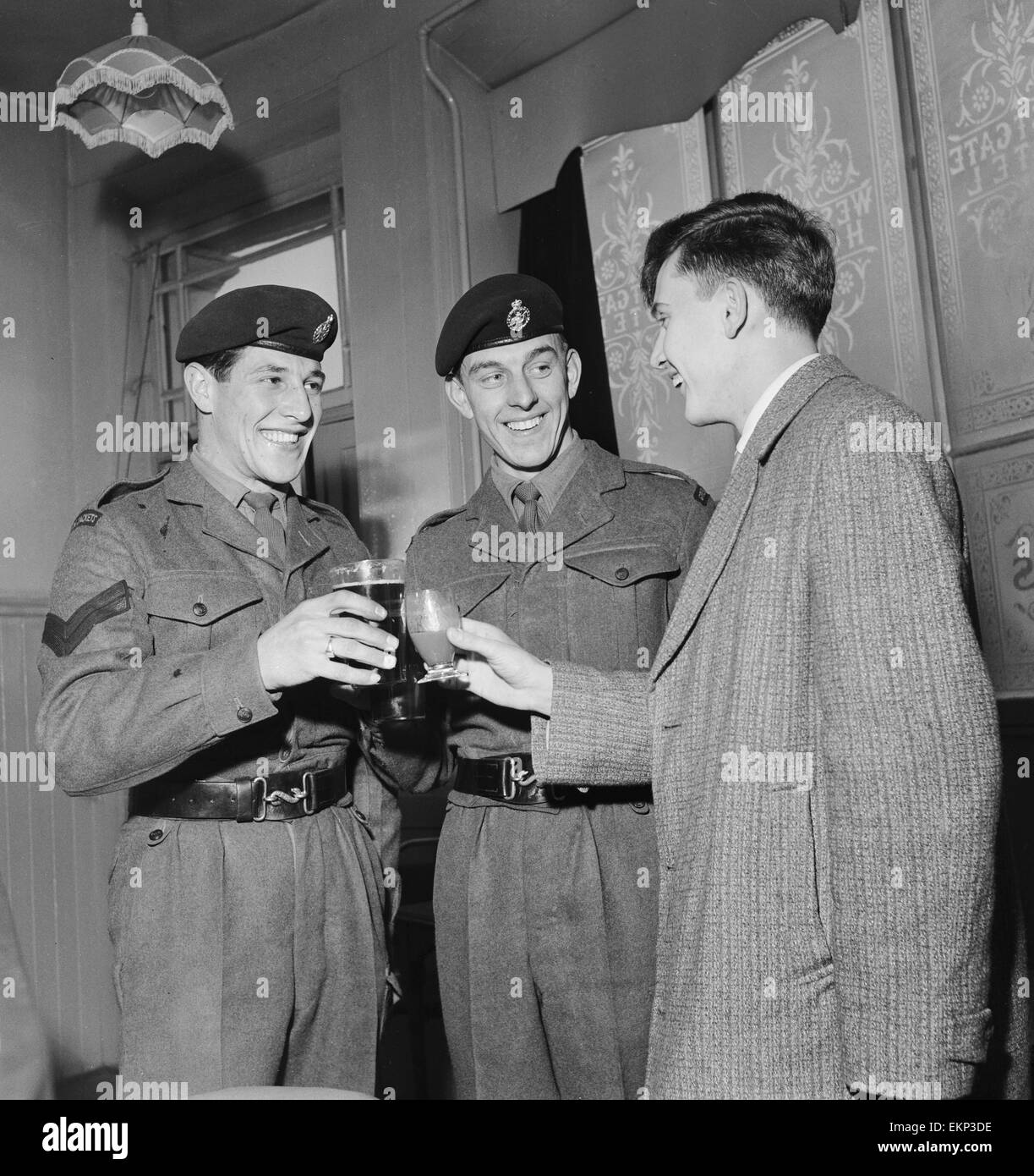 La chanteuse pop britannique Terry Dene (droite) bénéficie d'un verre avec le caporal B Goodall (à gauche) et le caporal Stamford au bar à Winchester casernes avant de commencer ses deux années de service dans l'armée. 16 janvier 1959. Banque D'Images