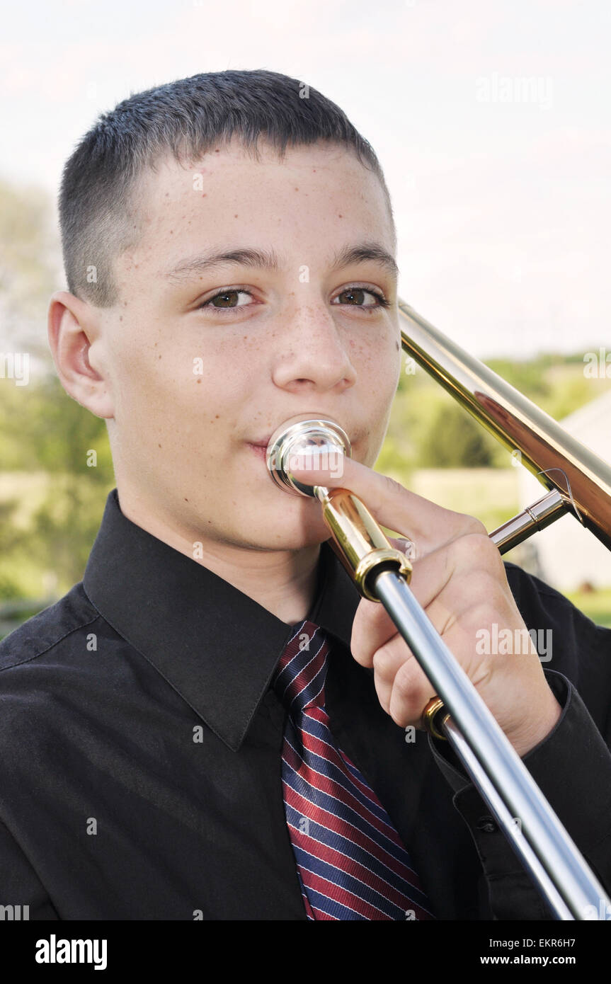 Teenage boy playing trombone Banque D'Images