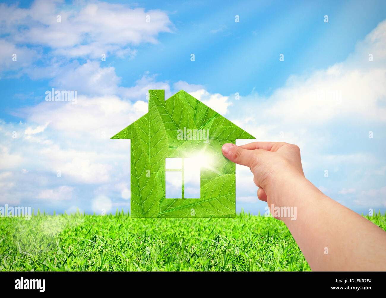 Hand holding green Maison avec terrain et fond de ciel bleu. Eco house concept Banque D'Images