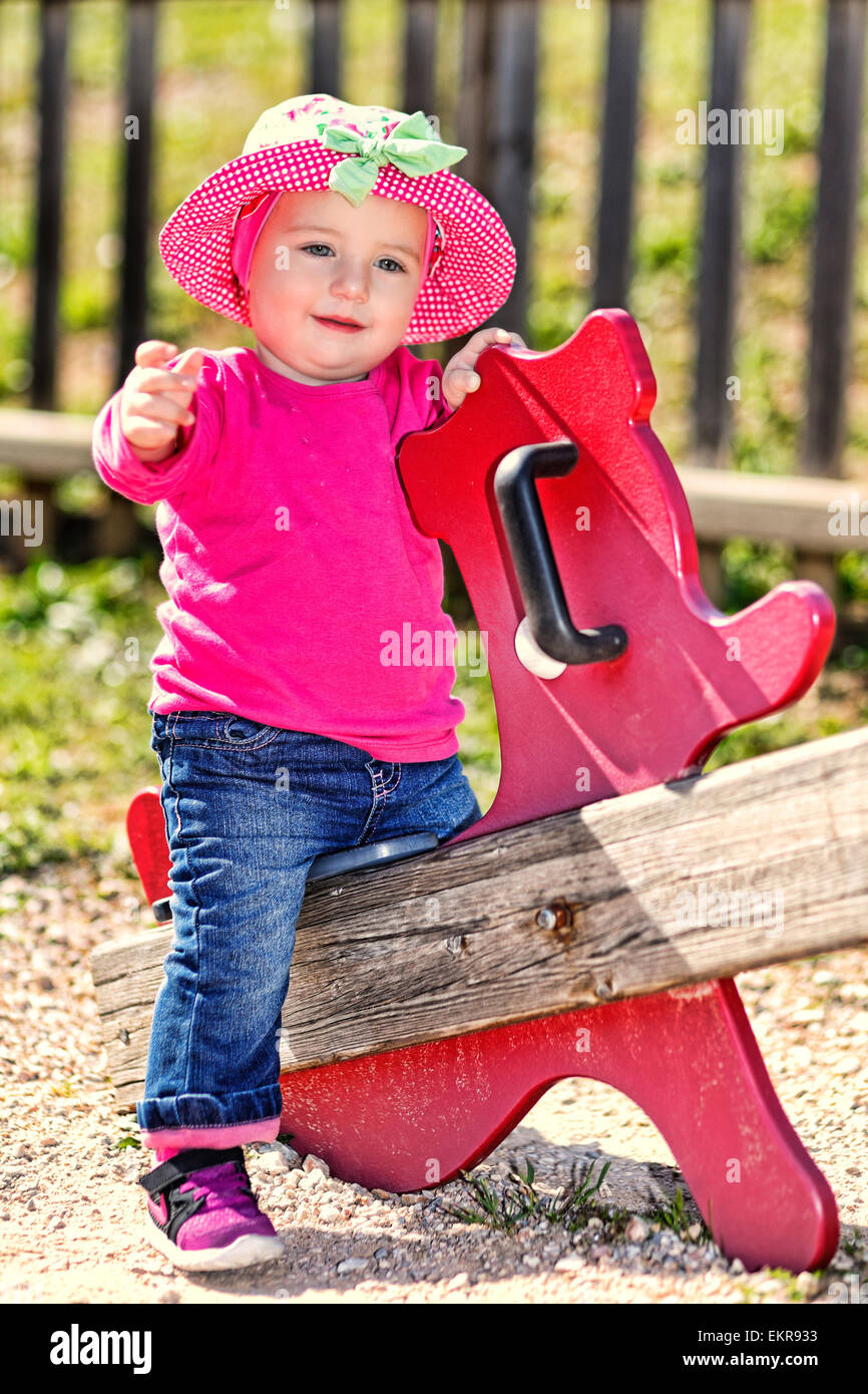 Une jolie petite fille avec chapeau rose s'amusant Banque D'Images