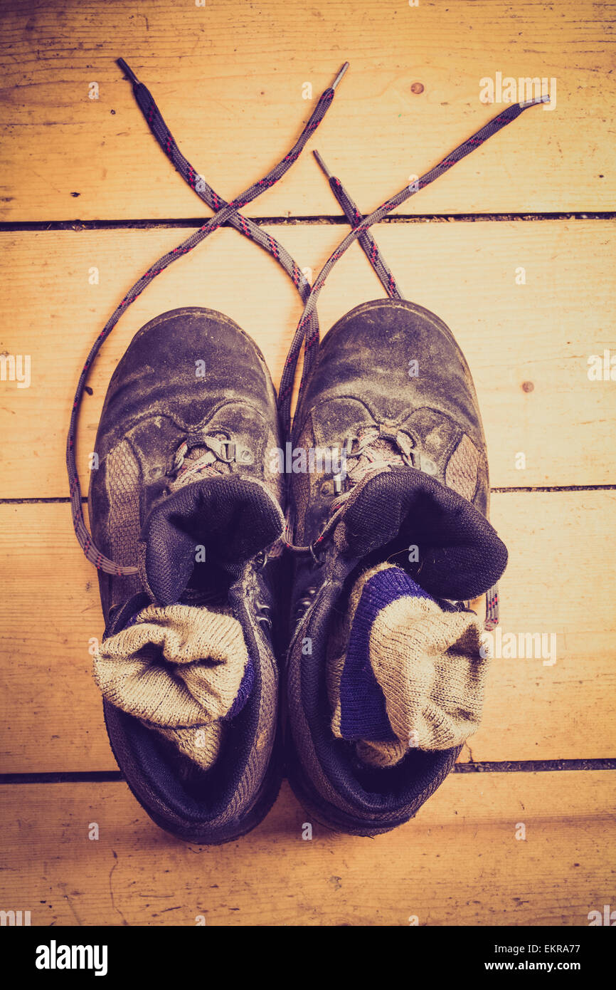 Chaussures de randonnée avec des chaussettes en eux sur un plancher en bois. Banque D'Images
