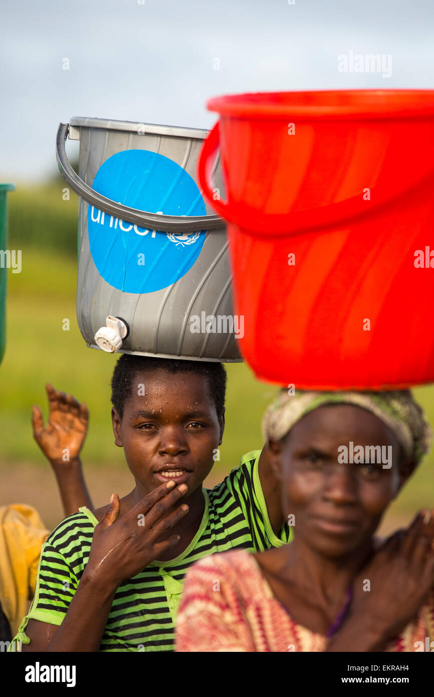 A la mi-janvier 2015, une période de trois jours de pluies excessives a unprecedneted les inondations au petit pays pauvre d'Afrique du Malawi. Il déplacé près de 250 000 personnes, a dévasté 64 000 hectares d'alnd, et tué plusieurs centaines de personnes. Cette photo montre une des femmes déplacées transportent de l'eau dans le camp de réfugiés de Chiteskesa, camp de réfugiés près de Mulanje. Banque D'Images