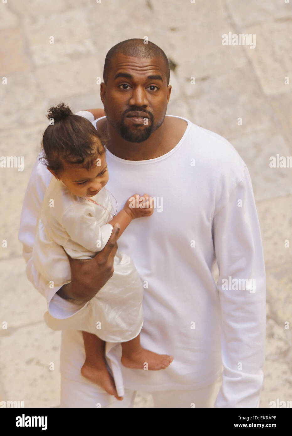 Jérusalem, Jérusalem, territoire palestinien. 13 avr, 2015. Le rappeur Kanye West détient sa fille après une cérémonie de baptême à la cathédrale St. James à Jérusalem Lundi, 13 avril, 2015. Dans une rapide visite à Jérusalem, la télé-réalité star américaine Kim Kardashian et le rappeur West avait leur tout-petit fille, Nord Ouest, baptisé le lundi à un 12e siècle église arménienne de la vieille ville fortifiée Crédit : Saeb Awad/APA/Images/fil ZUMA Alamy Live News Banque D'Images