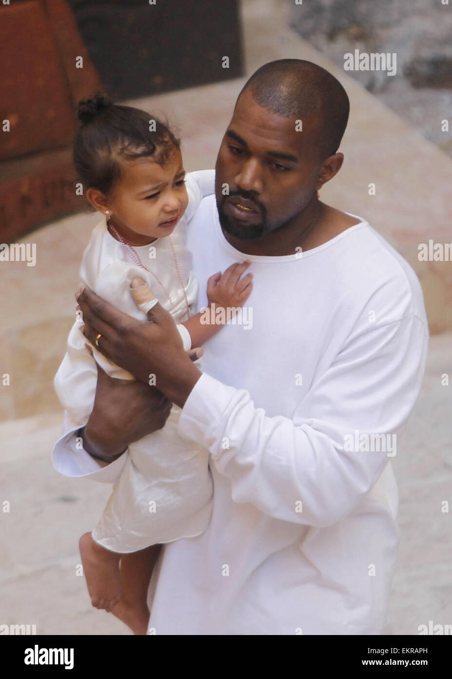 Jérusalem, Jérusalem, territoire palestinien. 13 avr, 2015. Le rappeur Kanye West détient sa fille après une cérémonie de baptême à la cathédrale St. James à Jérusalem Lundi, 13 avril, 2015. Dans une rapide visite à Jérusalem, la télé-réalité star américaine Kim Kardashian et le rappeur West avait leur tout-petit fille, Nord Ouest, baptisé le lundi à un 12e siècle église arménienne de la vieille ville fortifiée Crédit : Saeb Awad/APA/Images/fil ZUMA Alamy Live News Banque D'Images