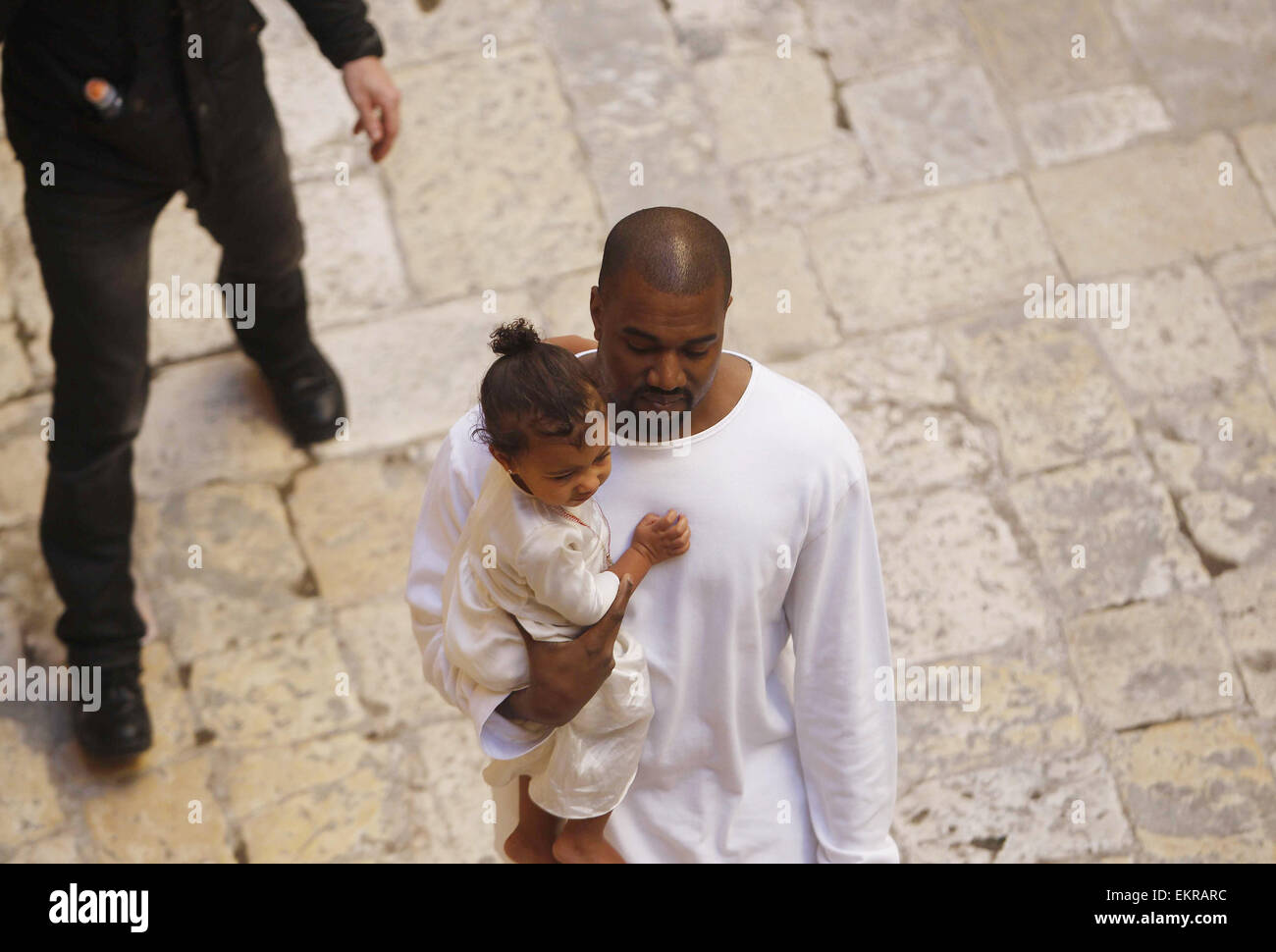 Jérusalem, Jérusalem, territoire palestinien. 13 avr, 2015. Le rappeur Kanye West détient sa fille après une cérémonie de baptême à la cathédrale St. James à Jérusalem Lundi, 13 avril, 2015. Dans une rapide visite à Jérusalem, la télé-réalité star américaine Kim Kardashian et le rappeur West avait leur tout-petit fille, Nord Ouest, baptisé le lundi à un 12e siècle église arménienne de la vieille ville fortifiée Crédit : Saeb Awad/APA/Images/fil ZUMA Alamy Live News Banque D'Images