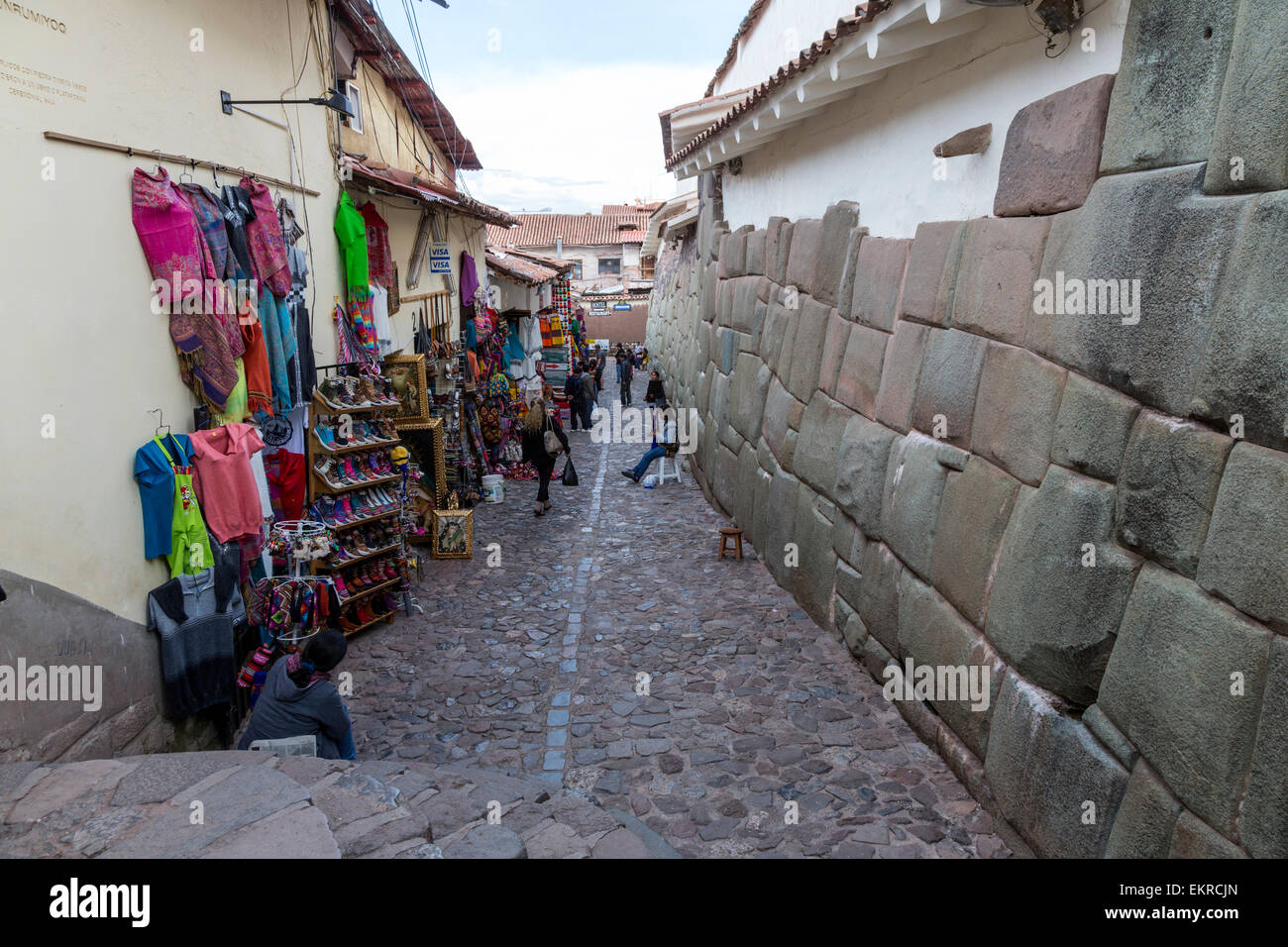 Pérou, Cusco. Vestiges de mur Inca le long de la rue des boutiques de souvenirs. Banque D'Images