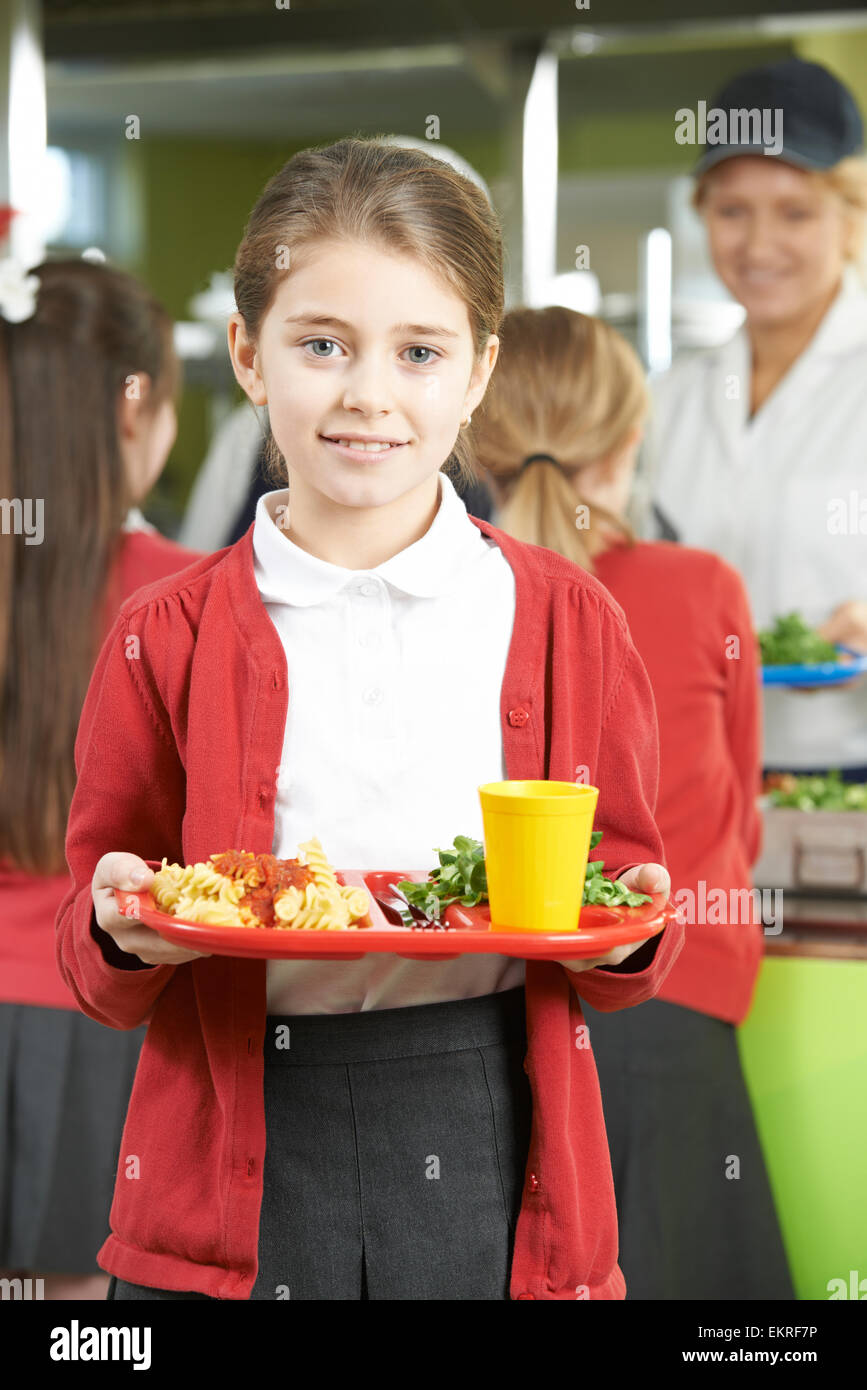 Élève de sexe féminin avec déjeuner sain dans la cafétéria de l'école Banque D'Images