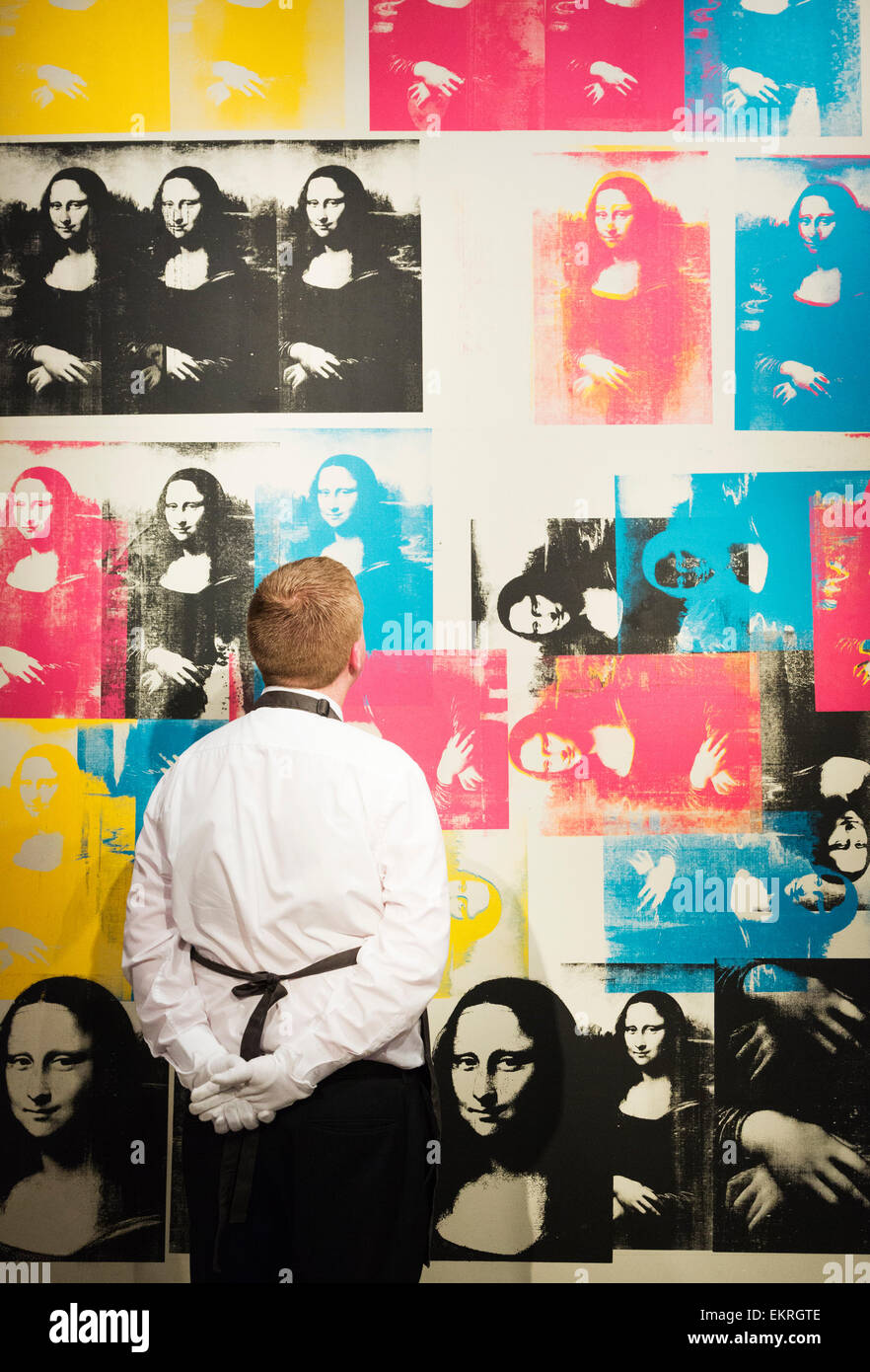 Londres, Royaume-Uni. 13 avril 2015. Un employé de Christie's se penche sur  l'Andy Warhol peinture couleur "Mona Lisa", nous estimer-$40m. Christie's  met en valeur une sélection de près de cinquante œuvres des