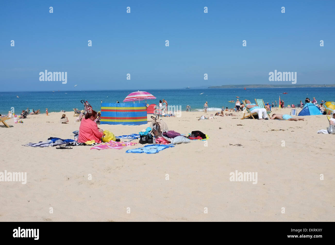Les personnes bénéficiant du beau temps sur la plage de Porthminster à St Ives en Cornouailles Banque D'Images