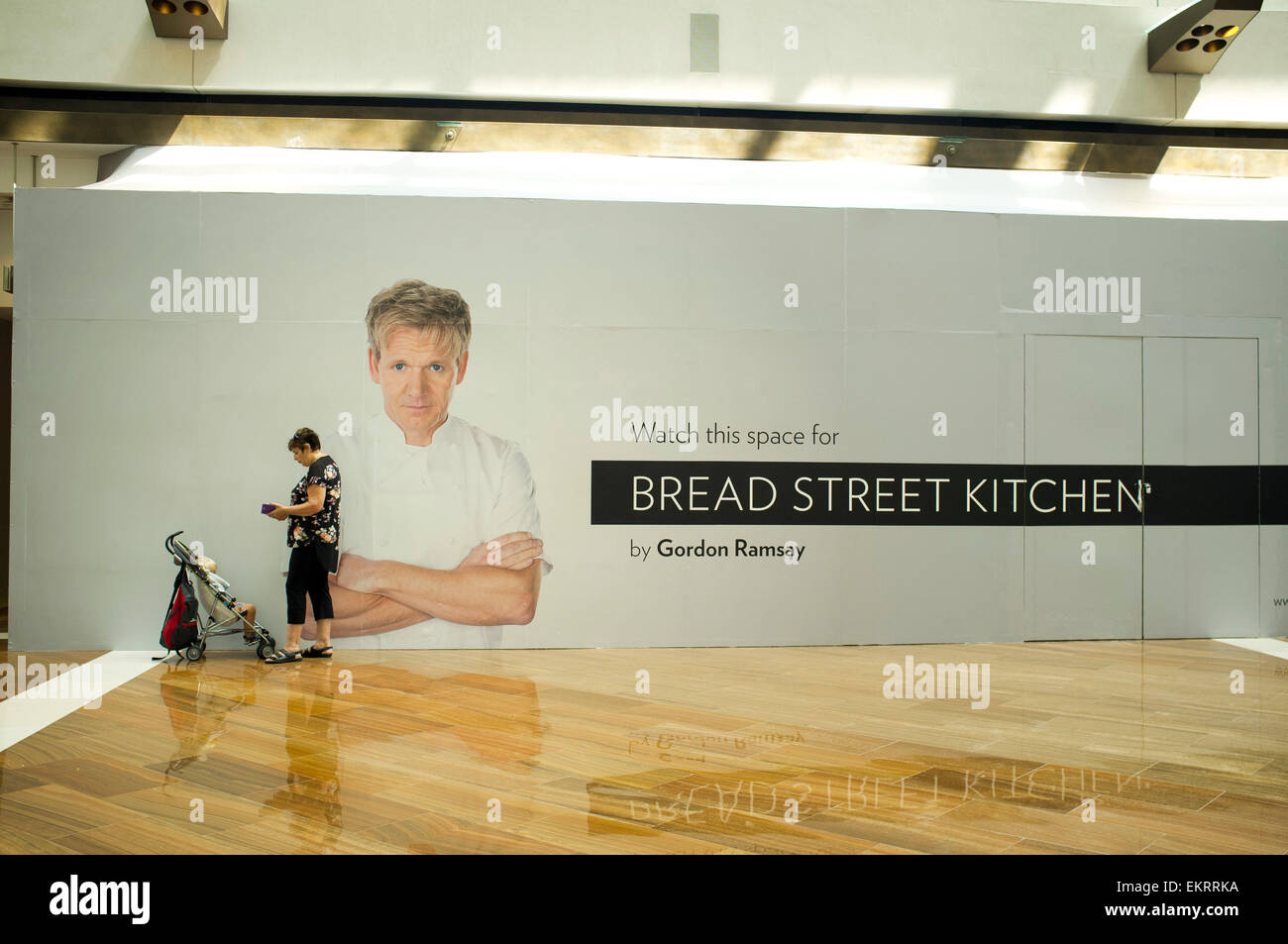 Singapour Le 14 avril 2015. Une femme avec un landau, devant une affiche mettant en vedette chef Gordon Ramsay qui ouvre un restaurant à Singapour : Crédit amer ghazzal/Alamy Live News Banque D'Images