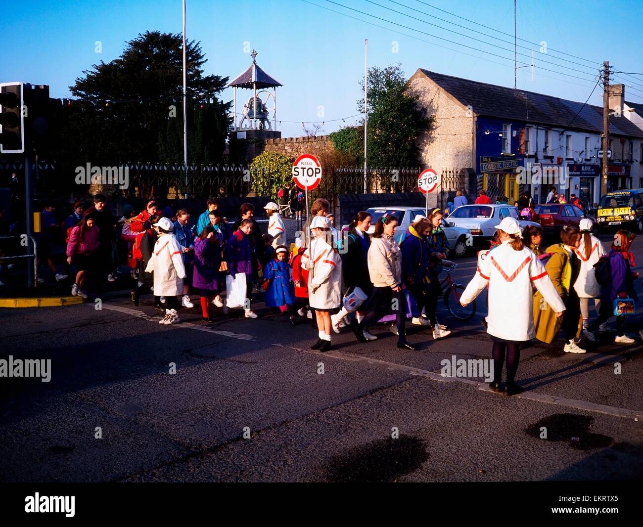 Les enfants de l'école de traverser la route avec l'école de patrouille Crossing Banque D'Images