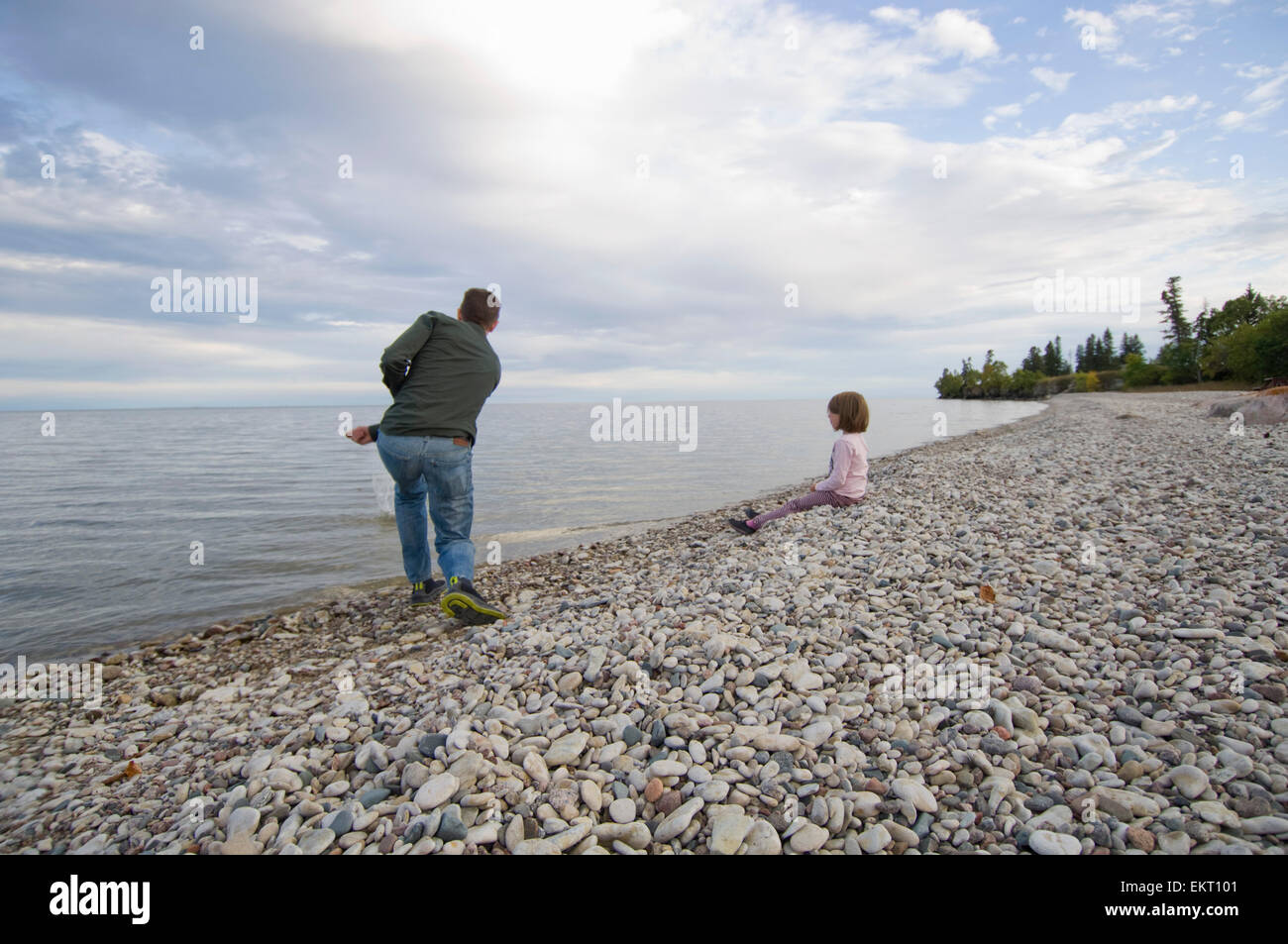 Père et fille sur le rivage rocheux du lac Winnipeg, l'île Hecla, Manitoba, Canada Banque D'Images