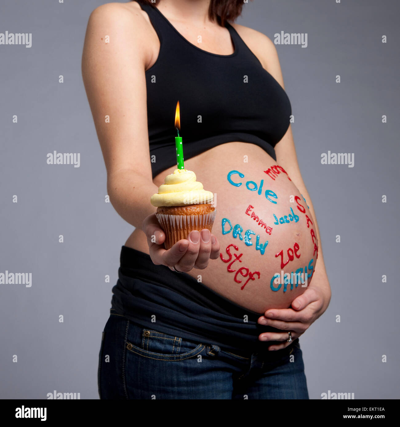Une Femme Enceinte Avec Des Noms De Bebe Sur Son Ventre Nu Tenant Un Petit Gateau Avec Bougie Allumee Edmonton Alberta Canada Photo Stock Alamy
