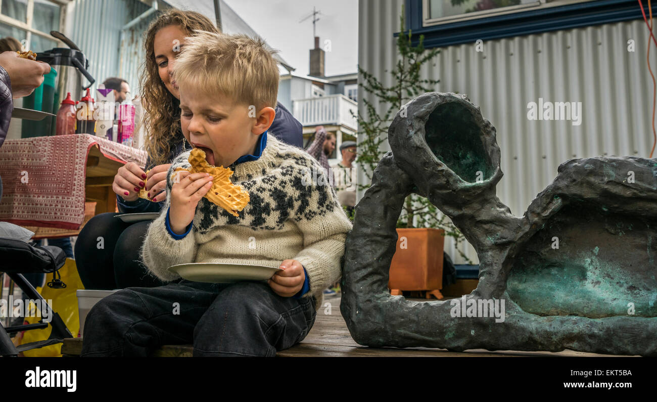 Garçon mangeant une gaufre. Festival annuel de fin de l'été (Festival culturel-Menningarnott), Reykjavik, Islande Banque D'Images
