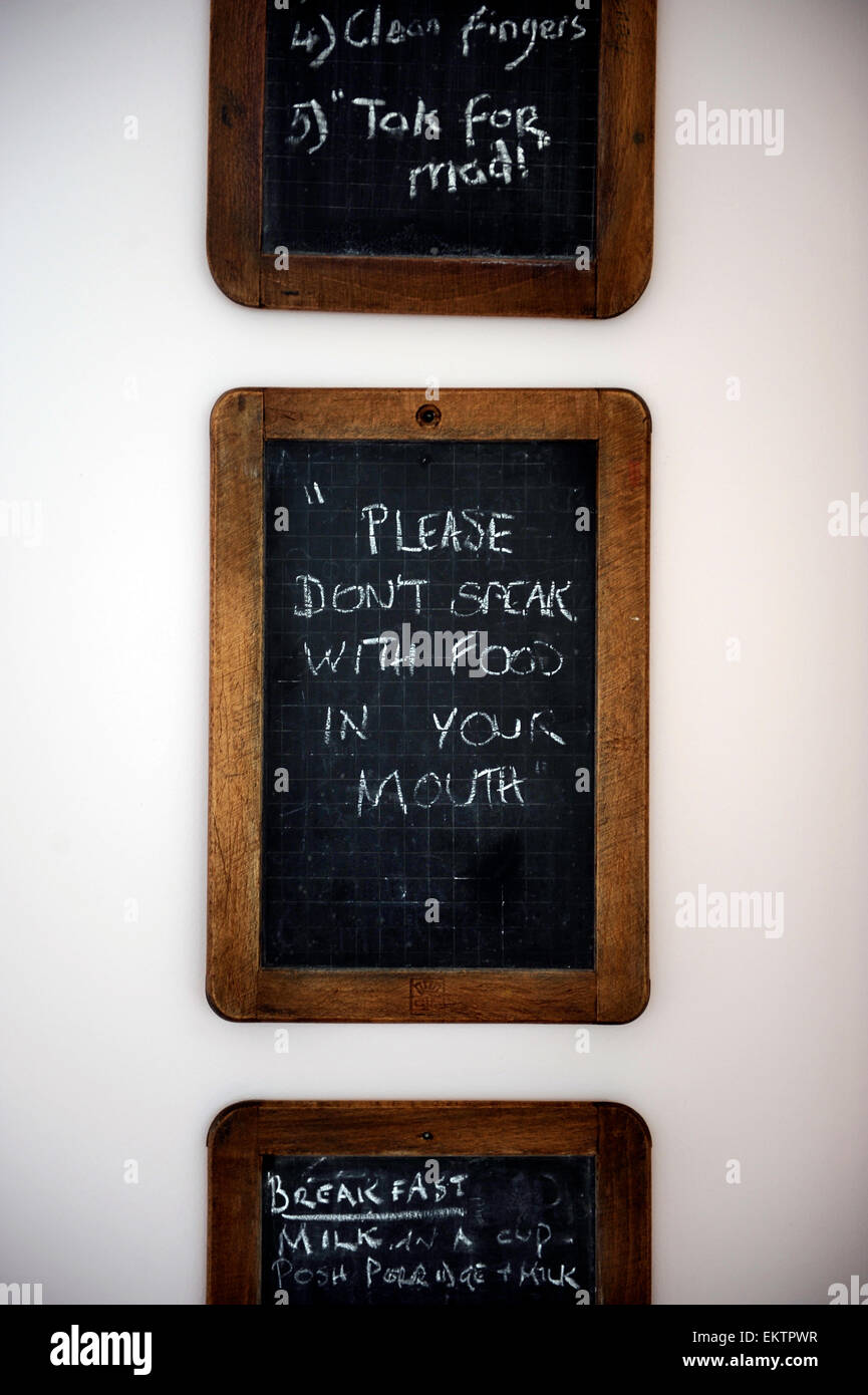 Un ensemble de tableaux sur un mur de cuisine avec des listes de courses, des mémos et des règles de la maison en disant "Merci de ne pas parler avec de la nourriture dans yo Banque D'Images