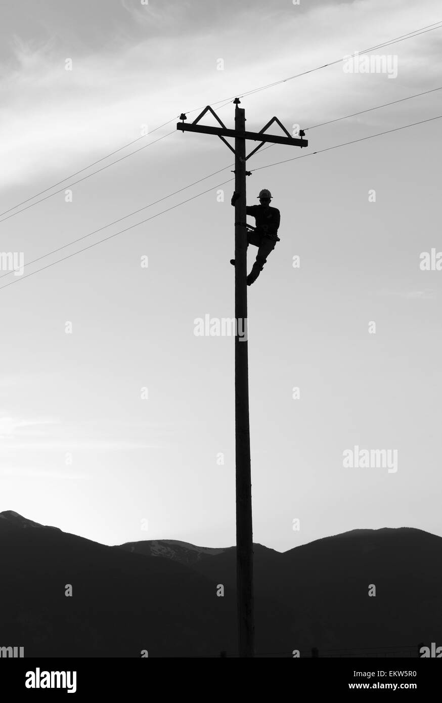 Silhouette d'un poseur de travailler sur un poteau de téléphone, Stevensville, Montana Banque D'Images