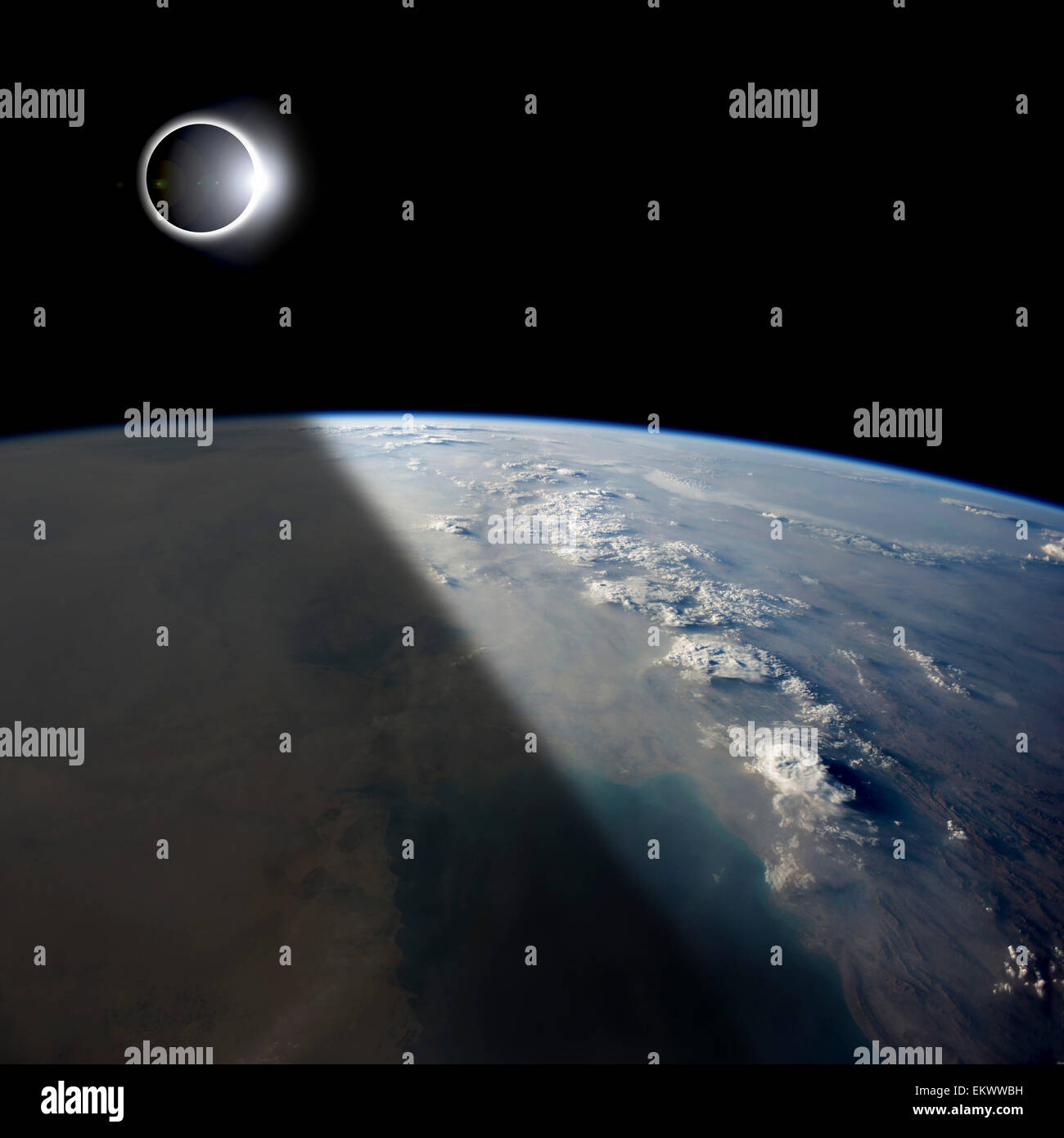 Les éclipses solaires teintes un partiellement la terre ci-dessous tandis que le soleil naissant allume le reste de la planète. Banque D'Images