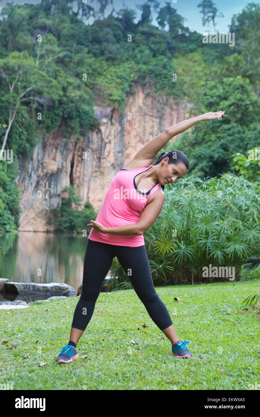 Sporty woman stretching côté droit du corps après l'exercice en extérieur parc Banque D'Images