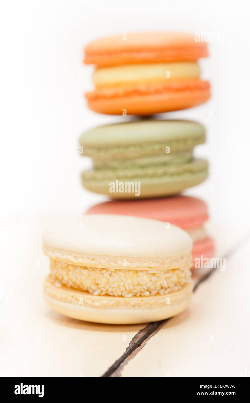 Macarons français colorés sur une table rustique en bois blanc Banque D'Images