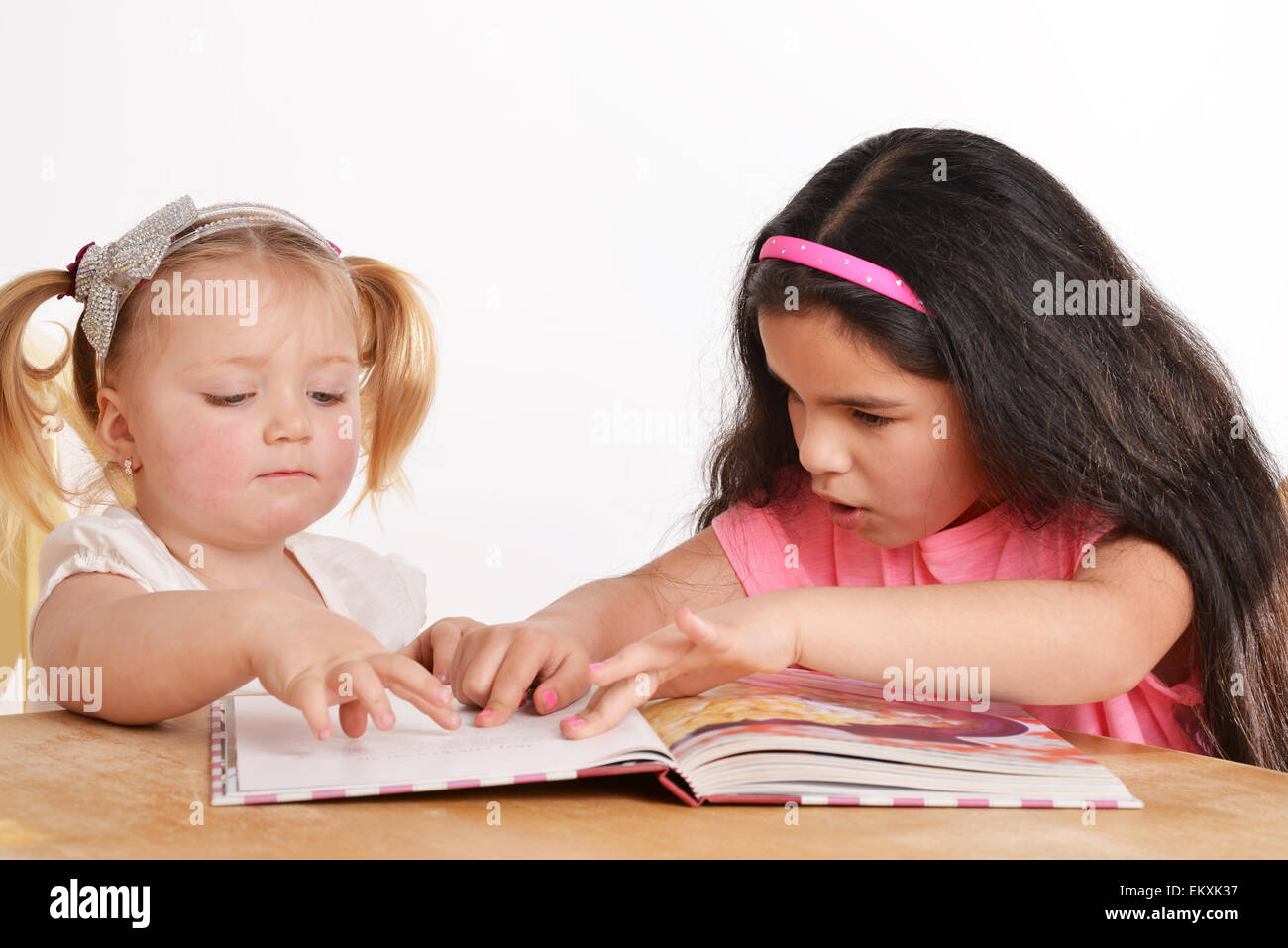 Deux jeunes filles lisant un livre à la maison Banque D'Images