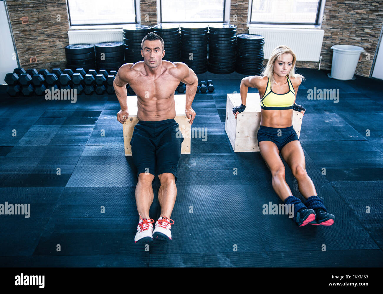 L'homme et la femme d'entraînement avec les mains sur monter fort at gym Banque D'Images