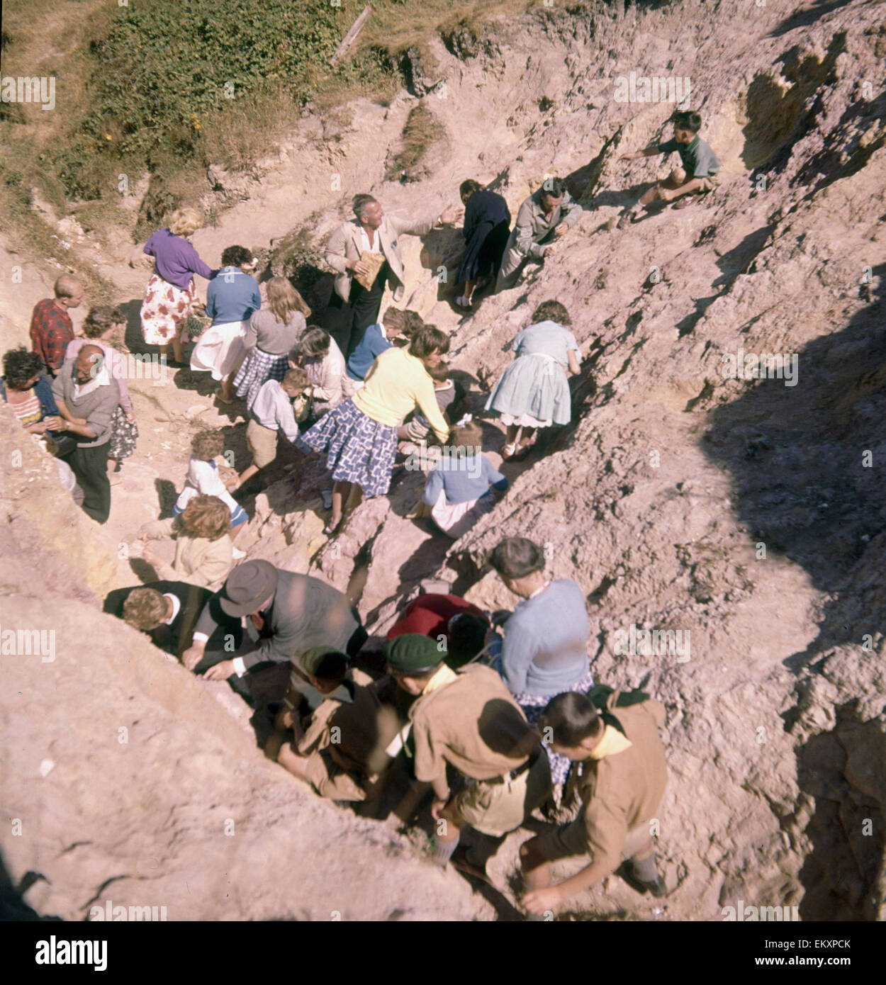 Les vacanciers de rayer les sables colorés de la falaise à l'Alum Bay, île de Wight. Août 1961. Banque D'Images