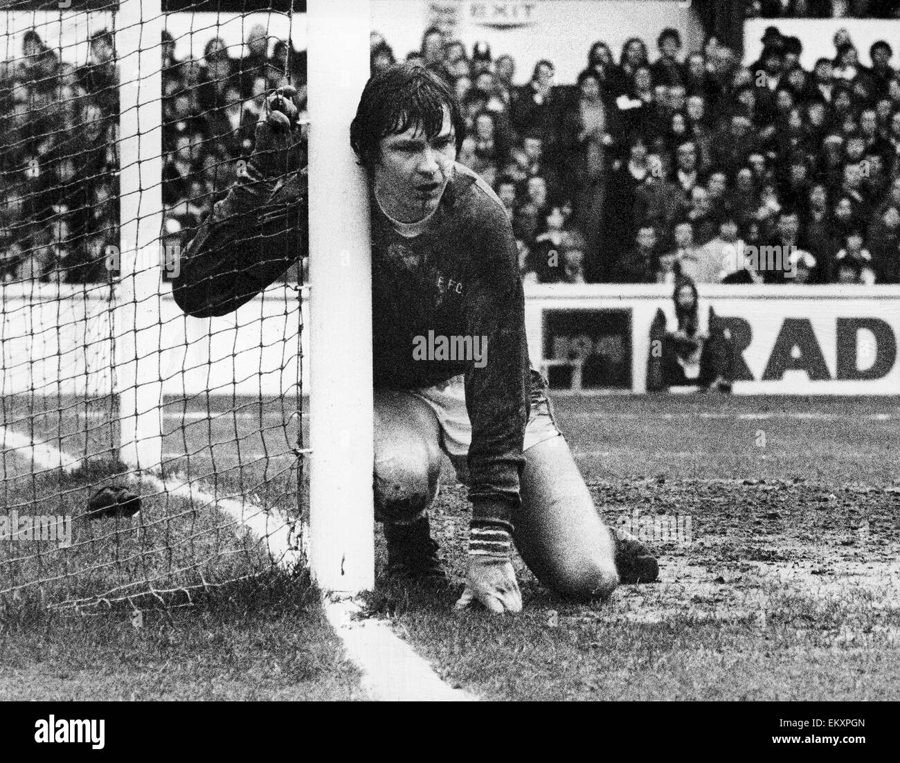 Everton keeper David Lawson accrochant sur le poste dans la douleur après avoir blessé lui-même tout en faisant un enregistrer. 26 mars 1977. Banque D'Images