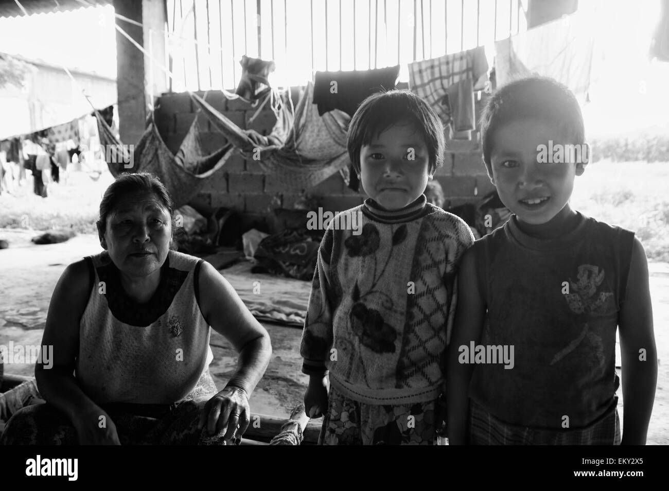 Deux enfants avec leur mère et une corde suspendue dans l'arrière-plan ; la Chine Yunnan Ruili Banque D'Images