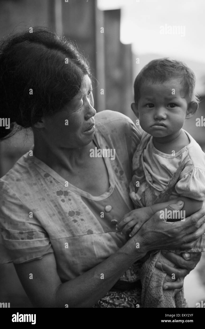 Une femme tenant un jeune enfant ; la Chine Yunnan Ruili Banque D'Images