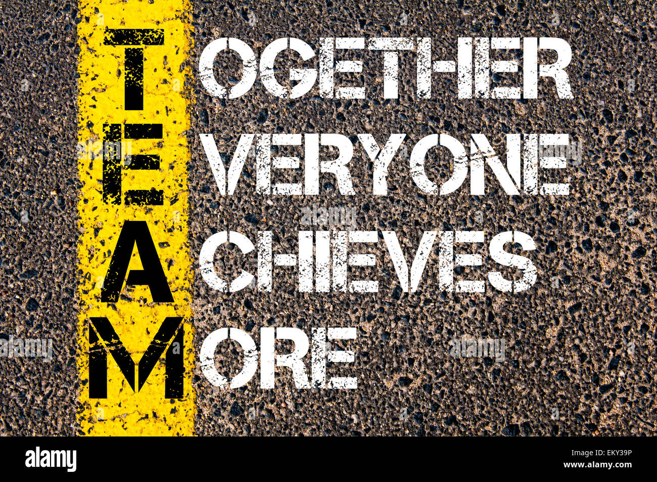 Ensemble, tout le monde obtient plus - Notion d'équipe. Image conceptuelle avec la ligne de peinture jaune sur la route asphaltée sur fond de pierre. Banque D'Images