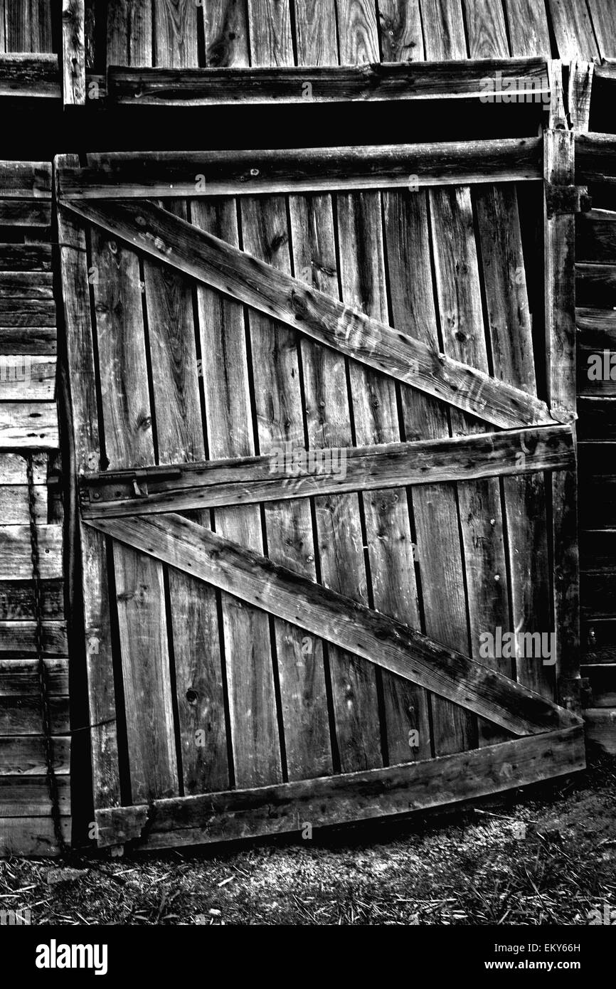 Porte en bois patiné avec serrure rouillée. Ancienne ferme à Olivenza, Espagne. Noir et blanc. Banque D'Images