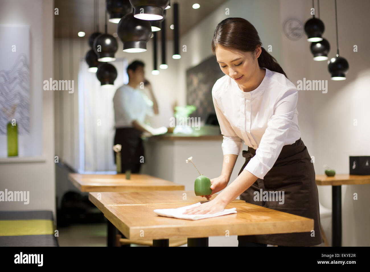 Jeune serveuse table essuyage Banque D'Images