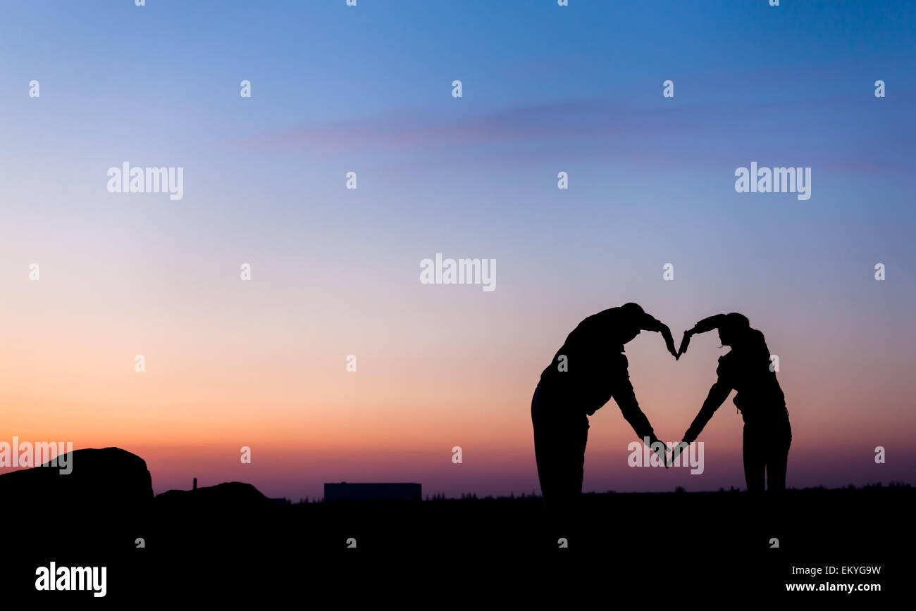 Forme de coeur conceptuel, symbole de l'humain. La femme et l'homme part d'ossature sur fond de ciel au coucher du soleil, métaphore de l'amour Banque D'Images