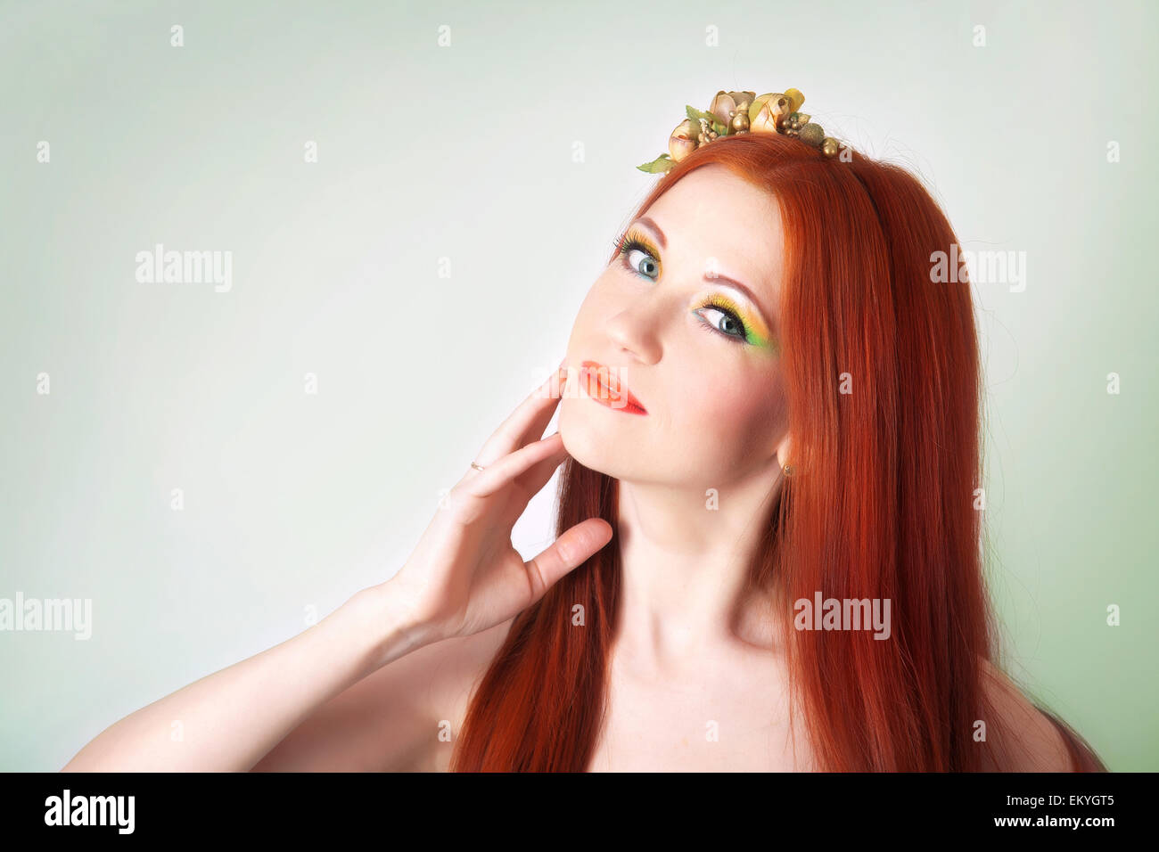 Portrait de la belle fille aux cheveux roux avec des fleurs dans ses cheveux et maquillage lumineux Banque D'Images