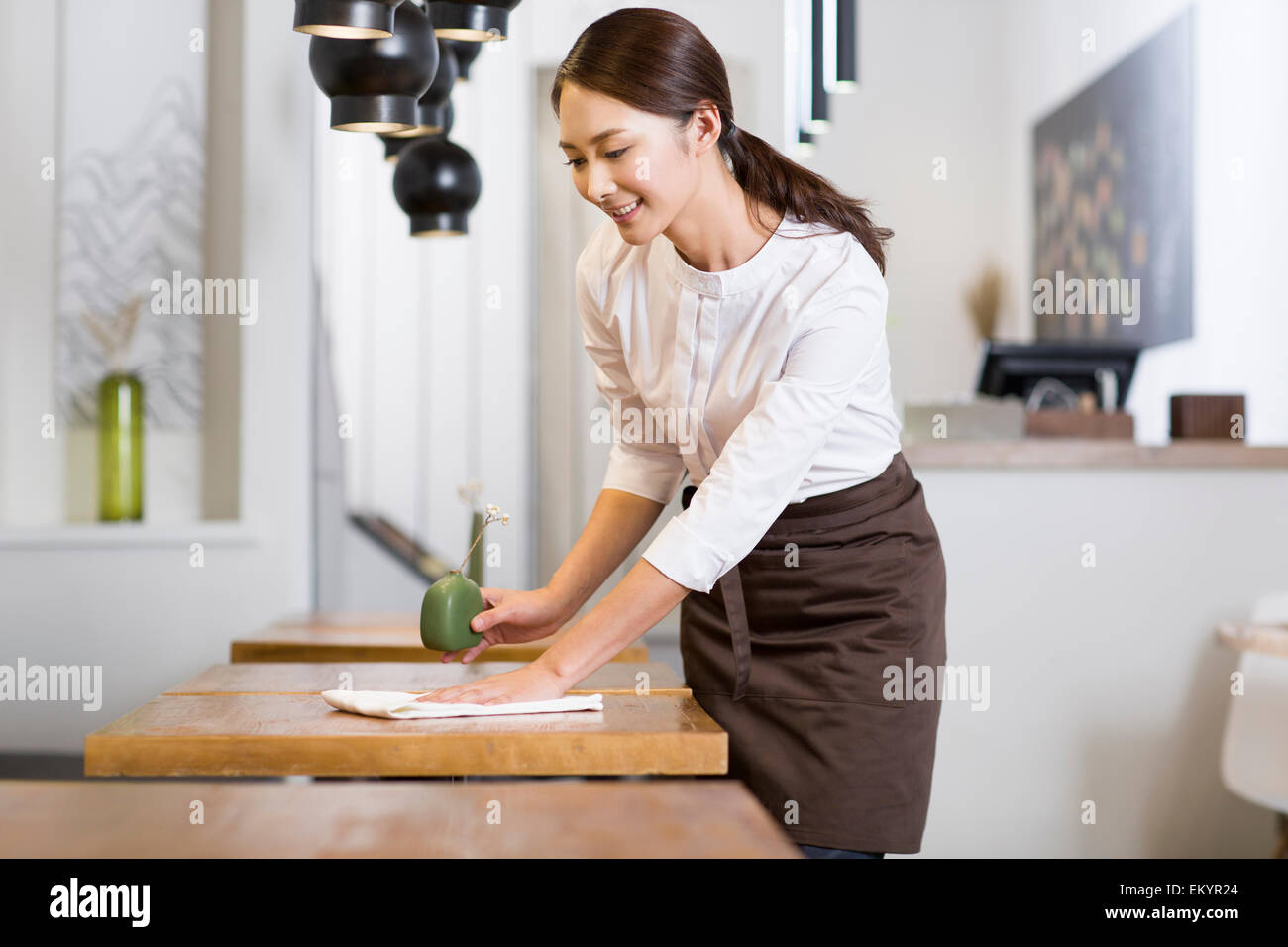 Jeune serveuse table essuyage Banque D'Images